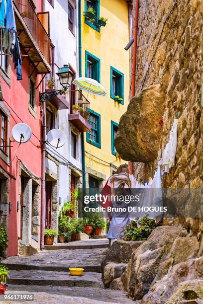 Une femme étendant son linge à sécher dans la rue en escalier de Pena Ventosa, 31 juillet 2017, Porto, Portugal.