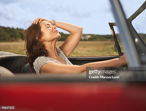 mid aged woman in sports car - convertible imagens e fotografias de stock