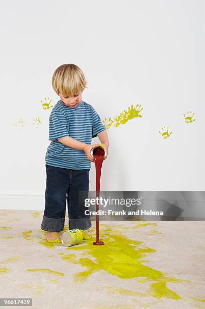toddler boy pouring paint onto carpet - damaged carpet stock pictures, royalty-free photos & images