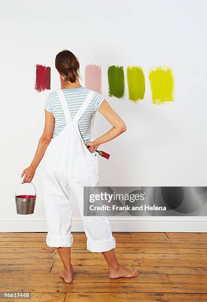woman looking at colour swatches on wall - farbprobe stock-fotos und bilder