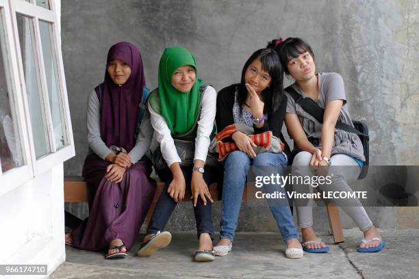 Groupe d?adolescentes indonésiennes, dont certaines sont voilées, dans la cour de récréation de l'école de Basca à Painan, au sud de l?île de...