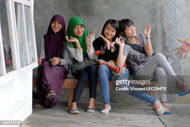 Groupe d?adolescentes indonésiennes, dont certaines sont voilées, dans la cour de récréation de l'école de Basca à Painan, au sud de l?île de...