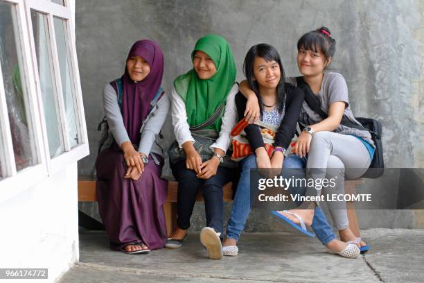 Groupe d?adolescentes indonésiennes, dont certaines sont voilées, dans la cour de récréation de l'école de Basca à Painan, au sud de l?île de...