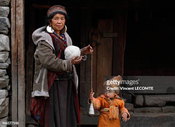 Femme Tamang filant de la laine, devant sa maison dans le village de Gatlang , au Népal, le 20 avril 2012.