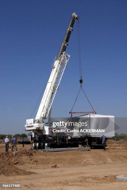 One half of a pre-fabricated home being unloaded from a tractor trailer truck as part of a new shipment of 12 pre-fabricated homes, intended to serve...