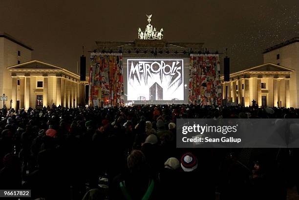 People gather in winter cold to view a screening of Fritz Lang's "Metropolis" at the Brandenburg Gate as part of the 60th Berlinale International...