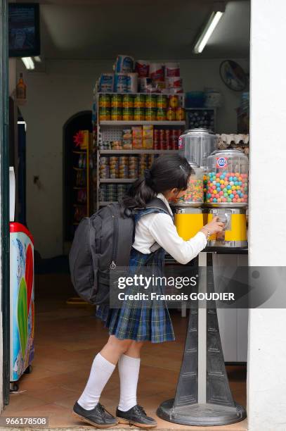 Petite fille devant un distributeur de chewing-gum à Villa de Leyva, 18 mars 2015, Colombie.