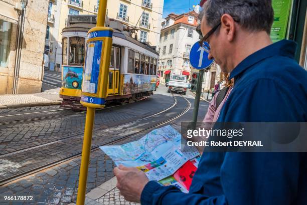Touriste consultant un plan du tramway électrique de la ligne n° 28 nommé "Elétricos" , le 31 mars 2017, Lisbonne, Portugal.