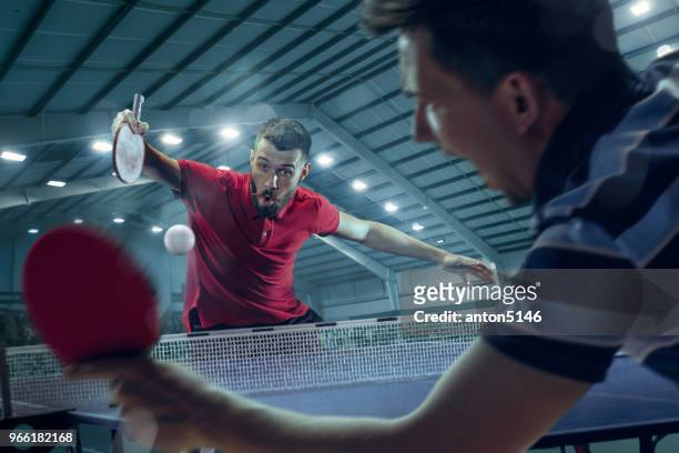 the young sports men tennis players in play on black arena background with lights - table tennis player stock pictures, royalty-free photos & images