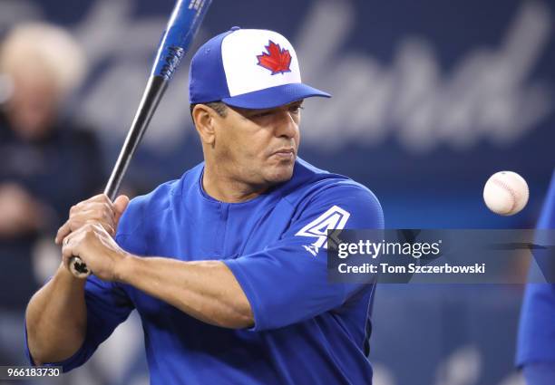 Third base coach Luis Rivera of the Toronto Blue Jays hits grounders with a fungo bat during batting practice before the start of MLB game action...