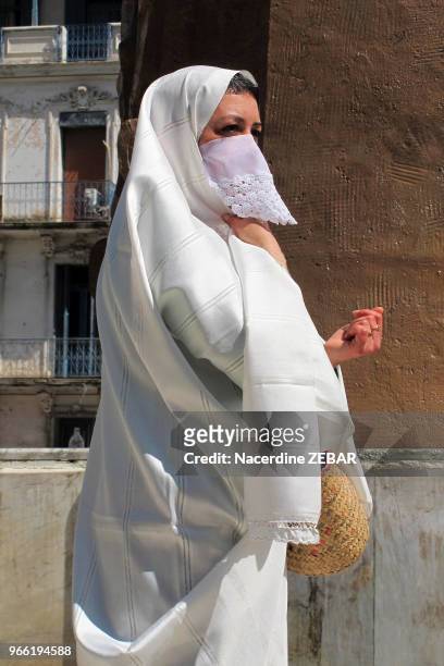 Femme algéroise portant une tenue traditionnelle le 'haik', étoffe symbole de pureté, dans une rue, le 21 mars 2013, à Alger, Algérie.