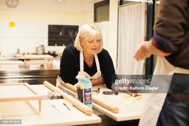 at italian cooking school: beautiful senior woman learning how to make pasta - kathrin ziegler stockfoto's en -beelden