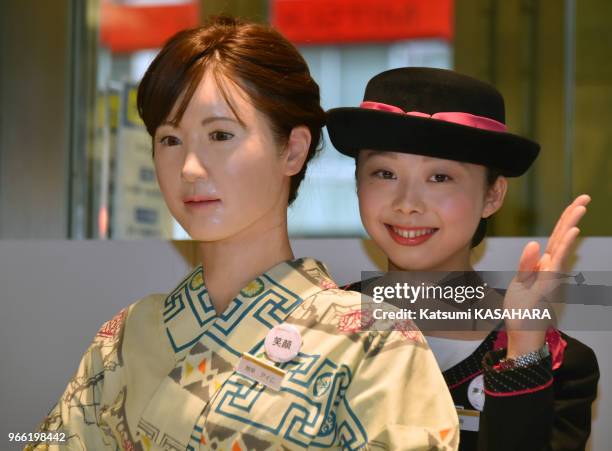 Un robot humanoïde appelé Aiko Chihira et produit par Toshiba, pose en compagnie d'une employée à un bureau de réception du magasin Mitsukoshi le 20...