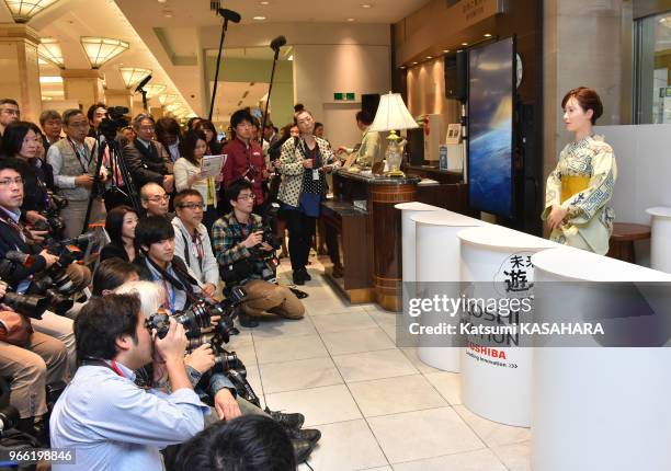 Un robot humanoïde appelé Aiko Chihira et produit par Toshiba, à un bureau de réception du magasin Mitsukoshi, entouré de photographes, le 20 avril...