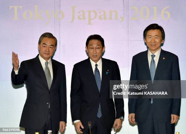 Japanese Foreign Minister Fumio Kishida, center, Chinese Foreign Minister Wang Yi, left, South Korean Foreign Minister Yun Byung-se, right, pose for...