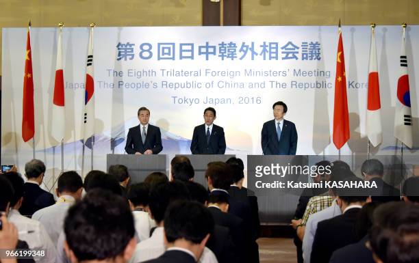 Japanese Foreign Minister Fumio Kishida, center, reads the statement after the trilateral meeting. Chinese Foreign Minister Wang Yi, left, South...