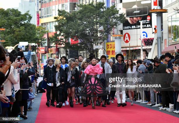 Jeunes designers autour de la chanteuse japonaise Maki Nomiya sur le tapis rouge lors d'un défilé de mode dans la rue principale du quartier de...