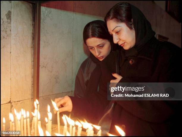 Two Christian girls light candels after general praying for Christmas time in St. Sarkis church in Tehran.
