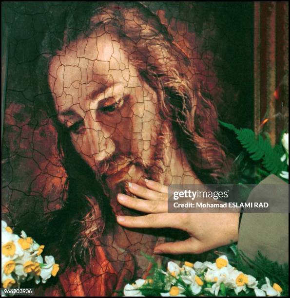 St. Sarkis church in Tehran at Christmas time. The hand of a Iranian Armenian girl touch the face of Jesus after christmas time praying.