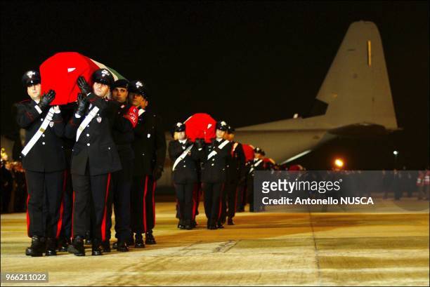 Italian Carabinieri carry the coffins of the 18 Italian soldiers killed in Iraq during the arrival ceremony at Ciampino military airport.