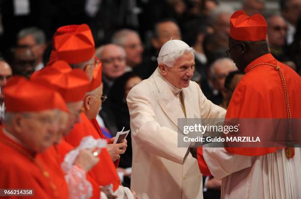 Former pope Benedict XVI greets a new cardinal after Pope Francis celebrated a consistory ceremony and consecrated 19 new members of the College of...