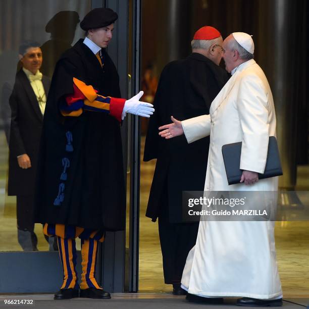 Le pape François salue un garde suisse lorsqu'il arrive dans la salle du synode au Vatican le 12 Février 2015 pour participer à un consistoire...