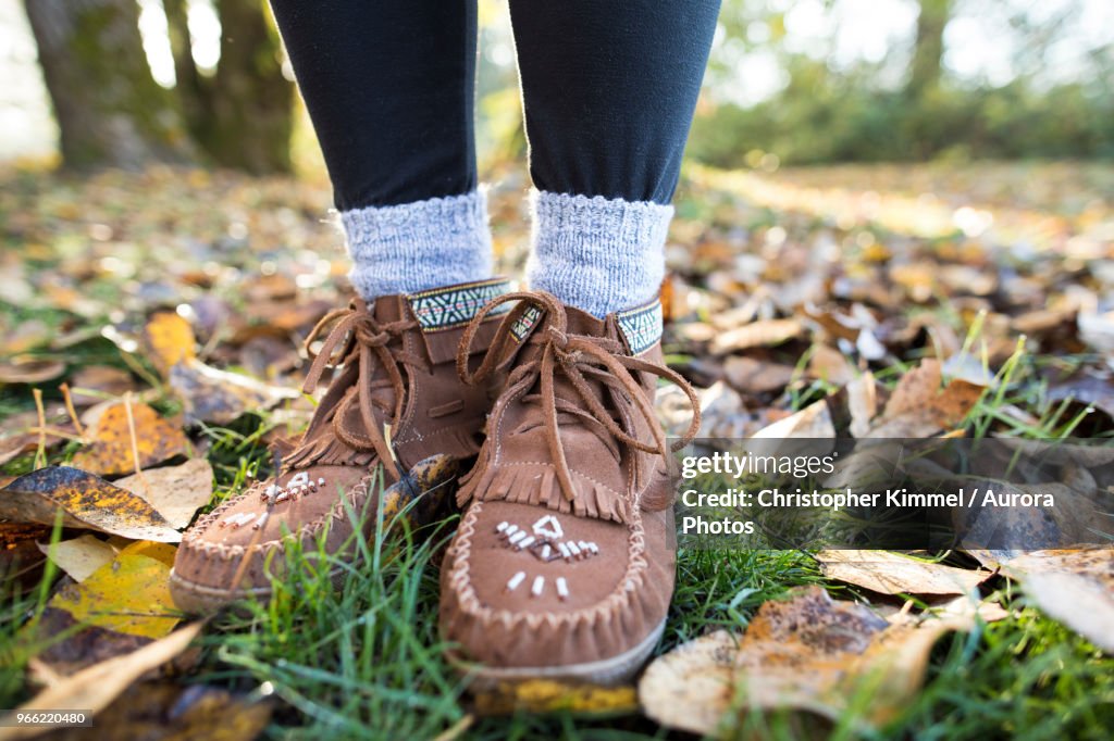 Moccasin shoes on legs of woman in park