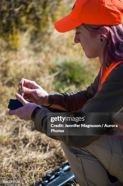 female hunter reloading rifle magazine, colorado, usa - ammunition magazine stockfoto's en -beelden