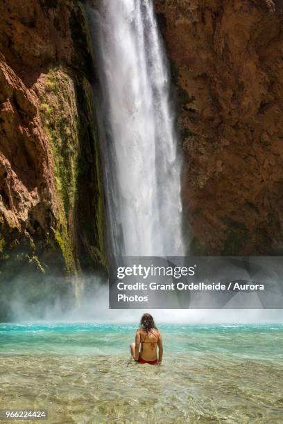 woman swimming below mooney falls, supai, arizona, usa - mooney falls stock pictures, royalty-free photos & images