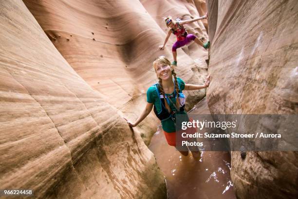 two women canyoneering through narrow zebra canyon, grand staircase-escalante national monument, utah, usa - canyoneering stock pictures, royalty-free photos & images