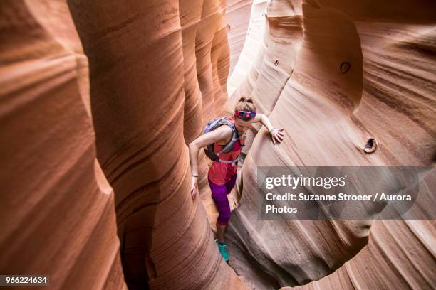 woman canyoneering through narrow zebra canyon, grand staircase-escalante national monument, utah, usa - slot canyon fotografías e imágenes de stock