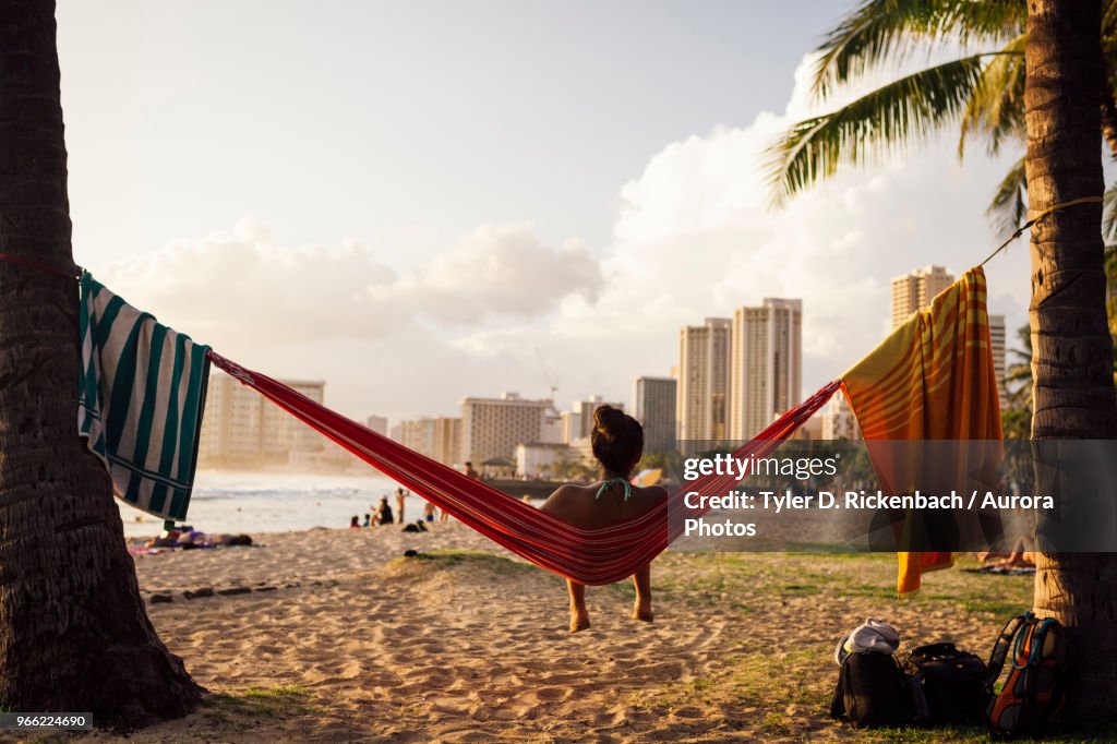 Young woman sitting in hammock at beach, Honolulu, Hawaii Islands, USA