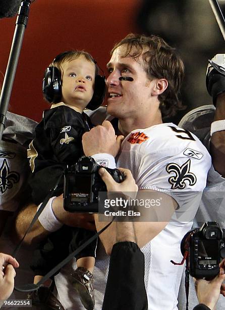Drew Brees of the New Orleans Saints holds his son Baylen Brees to celebrate after the Saints defeated the Indianapolis Colts during Super Bowl XLIV...