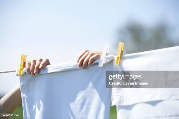 close-up of woman drying clothes on clothesline - white laundry stock-fotos und bilder