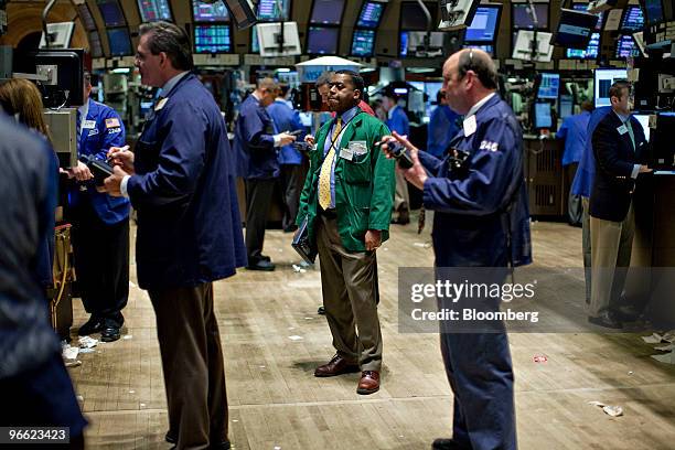 Traders work on the floor of the New York Stock Exchange in New York, U.S., on Friday, Feb. 12, 2010. U.S. Stocks, commodities and the euro fell as...