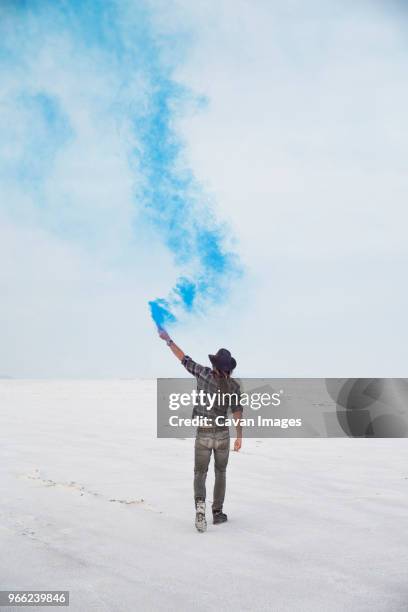 rear view of man holding smoke bomb while standing on bonneville salt flats against sky - bonneville salt flats stock pictures, royalty-free photos & images