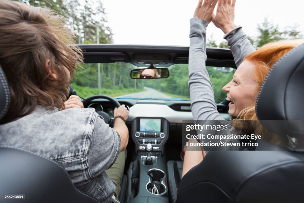 Couple driving in convertible