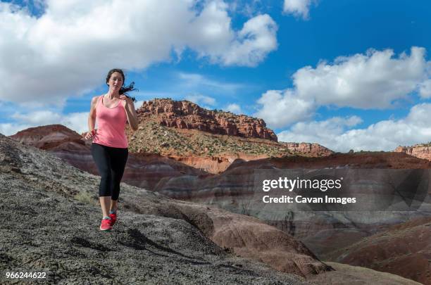 woman running on field against sky - paria canyon foto e immagini stock