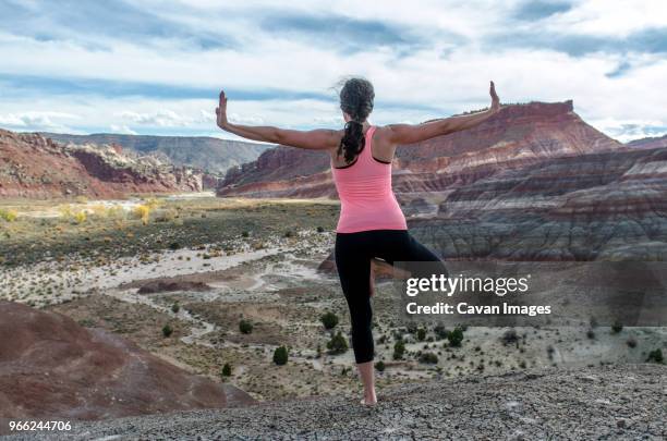 rear view of woman exercising on rock formations - paria canyon stockfoto's en -beelden