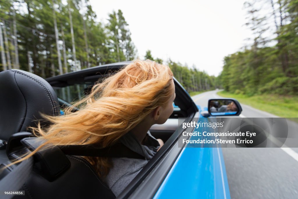 Young woman driving in convertible