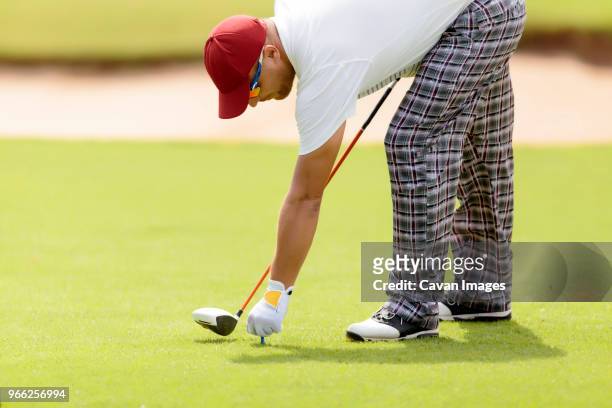 man holding tee while playing at golf course - bent golf club stock pictures, royalty-free photos & images