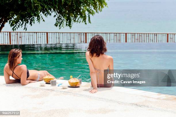 female friends relaxing at poolside - coconut water isolated stock pictures, royalty-free photos & images