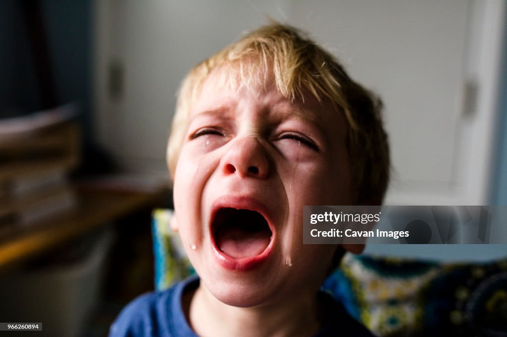 Close-up of boy crying at home