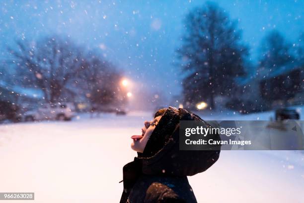 playful boy catching snowflakes on tongue - catching snow stock pictures, royalty-free photos & images