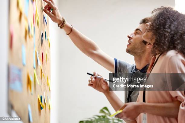 businessman pointing at note to businesswoman - strategy foto e immagini stock