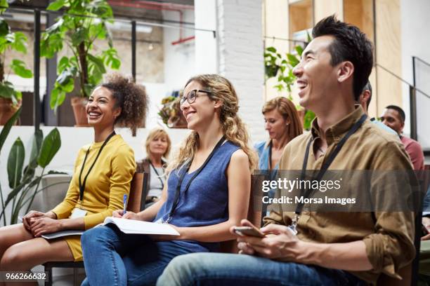 multi-ethnic business people smiling in seminar - geschäftskonferenz stock-fotos und bilder