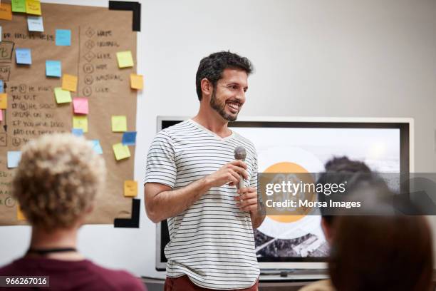 businessman giving presentation to colleagues - présentation discours photos et images de collection