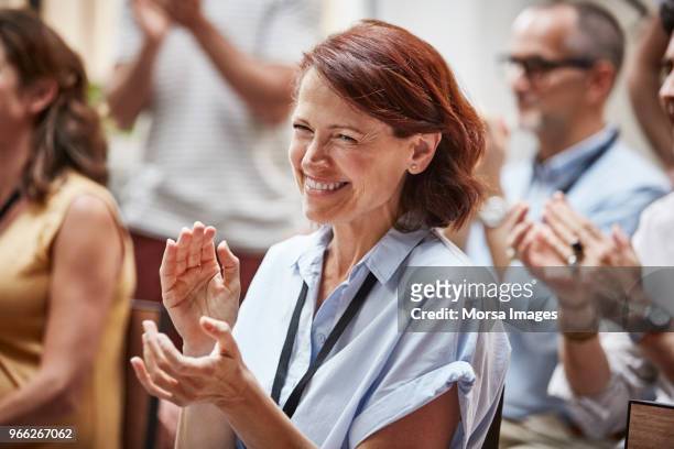 happy businesswoman applauding after presentation - aclamar fotografías e imágenes de stock