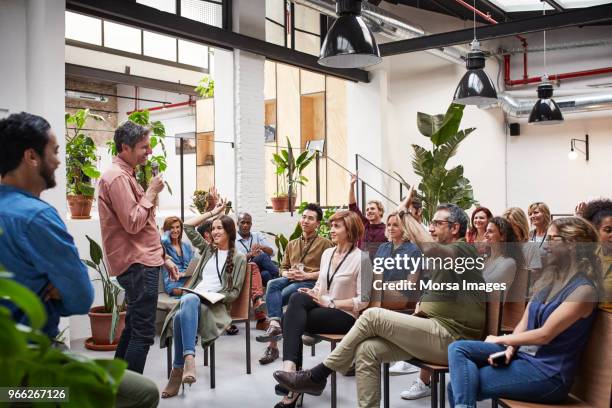 business people with raised arms during seminar - conversations fotografías e imágenes de stock