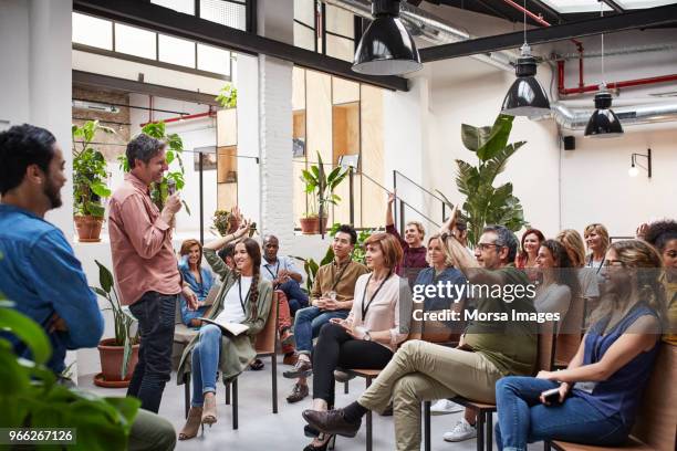 business people with raised arms during seminar - toespraak stockfoto's en -beelden
